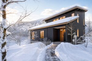 雪に覆われた山間の貸別荘と除雪された玄関までの通路