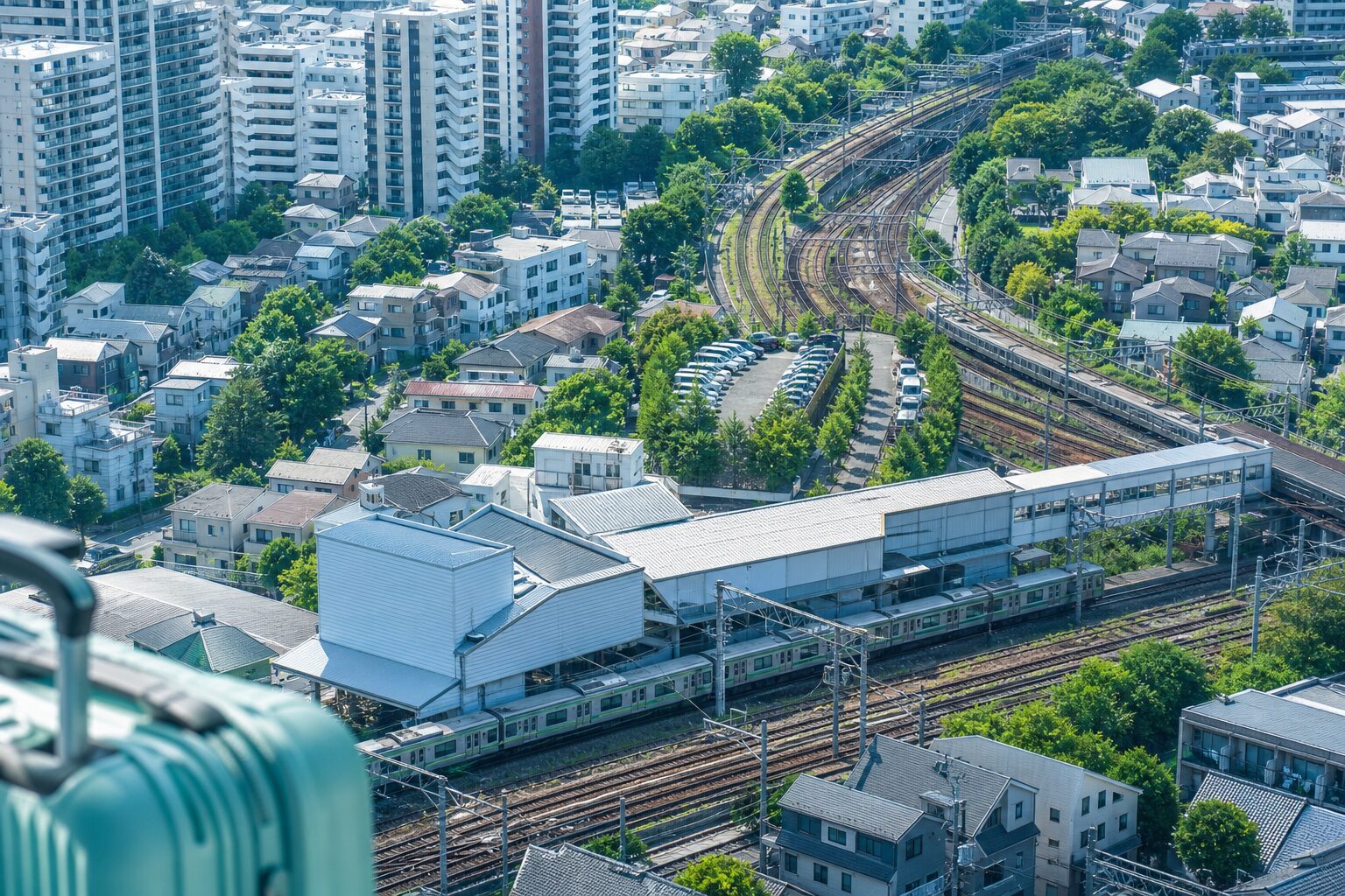 複数の鉄道路線と住宅街が見える都市部の民泊立地イメージ
